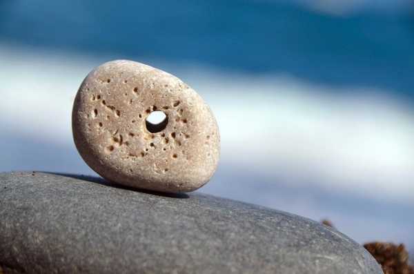 Камешек с дырочкой на берегу моря